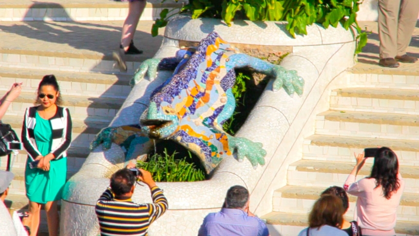 Turyści robiący zdjęcia jaszczurce w Park Güell