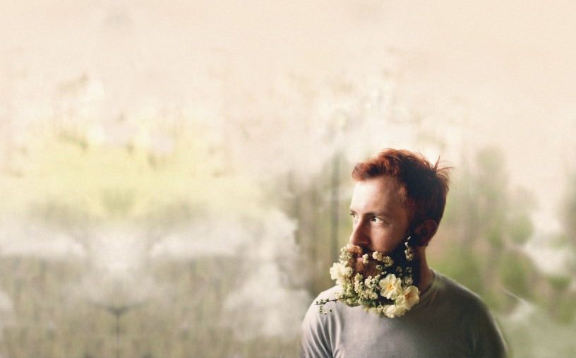 Hombre con flores en la barba