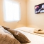 Makuuhuone, jossa on seinään kiinnitetty taulu HDTV