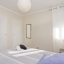 Goed verlichte kamer met tweepersoonsbed met gordijnen en zonwering