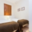 Slaapkamer met twee eenpersoonsbedden met garderobe